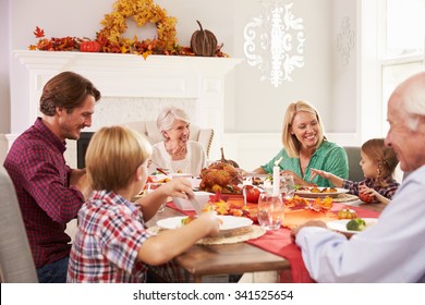 Family With Grandparents Enjoying Thanksgiving Meal At Table