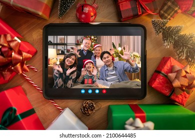 Family Greeting Distance Relation  Tablet Device Between Christmas Decoration.tablet With Asian Family Say Hi Hello Background. Christmas Frame For Greeting Card. View From Above With Copy Space