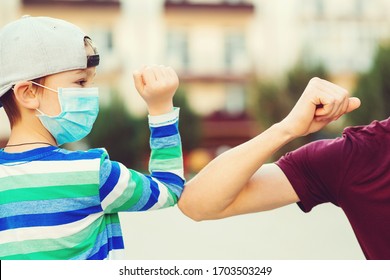Family greeting style with elbows. Coronavirus quarantine. Social distancing concept. Family, lifestyle, new style of greetings. Kid and father greeting with elbows outdoors. Coronavirus prevention.