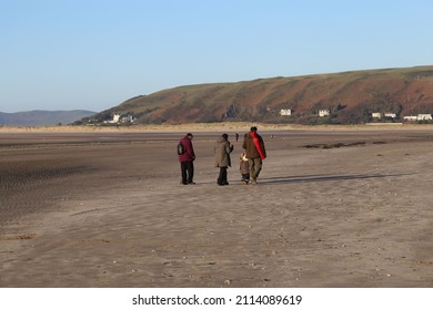 A Family Group Enjoying A Winter Walk On Ynysalas Beach, Ceredigion, Wales, UK.