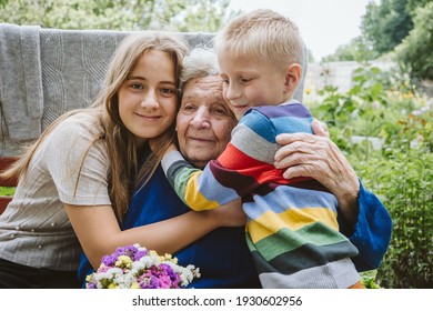 Family Groups, Multigenerational Households, Great-grandmother And Great-grandchildren. Candid Portrait Of Happy Grandmother With Grandchildren Outdoors.