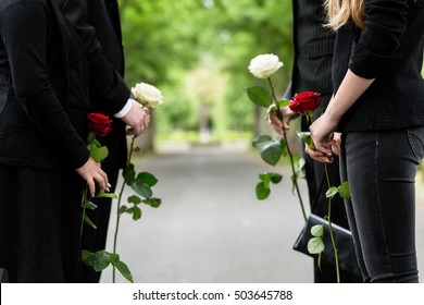 Family in guard of honor at funeral, only torso of people to be seen - Powered by Shutterstock