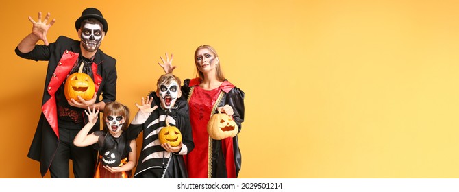 Family In Halloween Costumes On Color Background With Space For Text