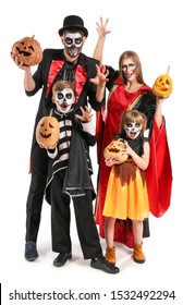 Family In Halloween Costumes And With Pumpkins On White Background