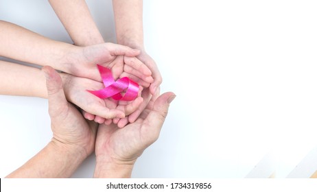 Family Hand holding red pink ribbon on white background.
October breast cancer awareness month.
Women day and World cancer day concept.
top view.   - Shutterstock ID 1734319856