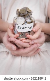 Family Hands Holding A Money Jar Of Australian Money Labelled Education