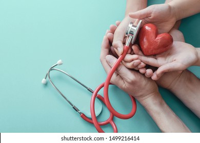 Family hands holding red heart with stethoscope, heart health,  health insurance concept, World heart day, world health day, cardiovascular, hypertension concept