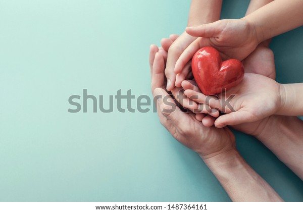 Family hands holding red heart, heart health\
insurance, organ donation, happy volunteer charity, CSR social\
responsibility,world heart day, world health day,world mental\
health day,foster home\
concept
