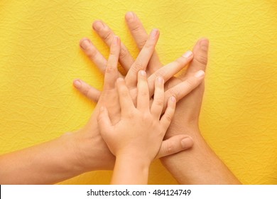 Family Hands On Yellow Background