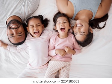 Family Happy, Crazy Children And Above Bed With Parents In The Morning, Funny Face In The House And Comic Portrait Together In Home. Top View Of Mother And Dad Smile With Girl Kids In Bedroom