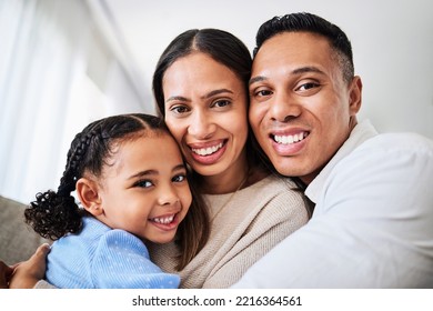 Family, Happy And Face Portrait In Living Room Home, Smiling And Bonding. Love, Care And Happy Parents, Child Or Girl Hugging, Embrace Or Spending Quality Time Together In House With Smile Or Support