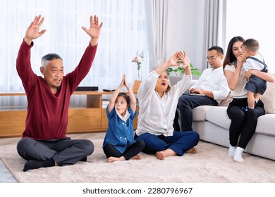 The family have fun relax engaged in fitness yoga at home using online instruction from laptop - Shutterstock ID 2280796967