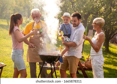 Family having a barbecue party, mother ,father ,son and grandparents standing around the grill. - Powered by Shutterstock