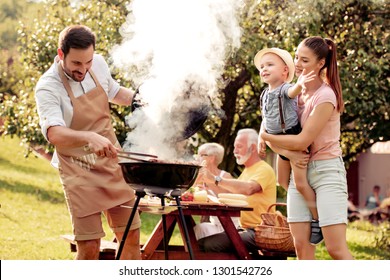 Family having a barbecue party in their garden in summer. - Powered by Shutterstock