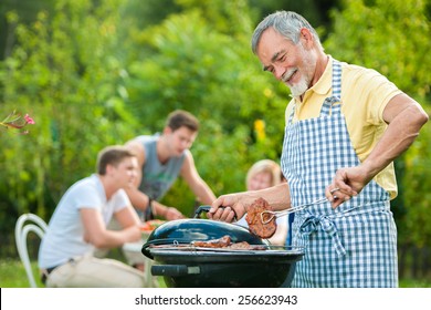 Family having a barbecue party in their garden in summer - Powered by Shutterstock