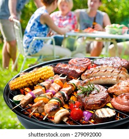 Family Having A Barbecue Party In Their Garden In Summer