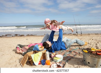 Family Having Barbeque On Winter Beach