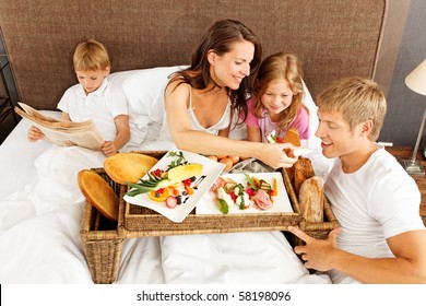 Family Having Breakfast In Bed - Boy Reading Newspaper