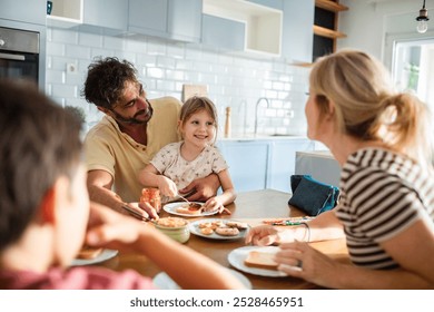 Family having breakfast together at the kitchen table - Powered by Shutterstock