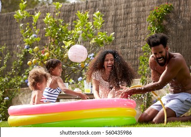 Family Having Fun In Garden Paddling Pool