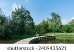 A family having fun in the Hong Kong Wetland Park, in Tin Shui Wai, on a sunny summer afternoon. The father is holding his son