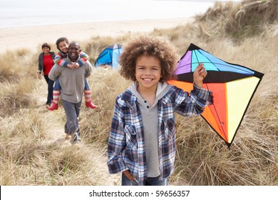 Family Having Fun With Kite In Sand Dunes