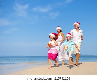 Family Having Fun On The Beach On Christmas.