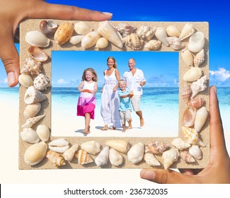 Family Having Fun On The Beach With Picture Frame.