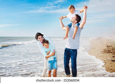 Family Having Fun On The Beach To The Sea