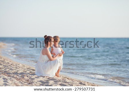 Family having fun on the beach collecting seashells 
