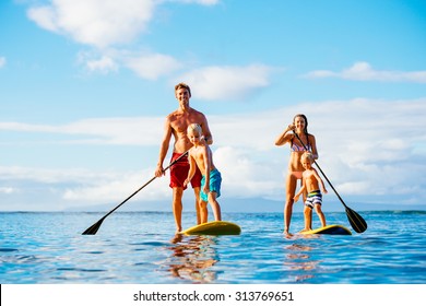 Family Having Fun Stand Up Paddling Together in the Ocean on Beautiful Sunny Morning