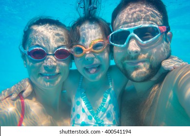 Family Having Fun In Swimming Pool. Underwater Funny Selfie. Summer Vacation