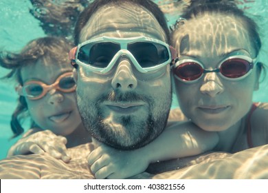 Family Having Fun In Swimming Pool. Underwater Funny Portrait. Summer Vacation