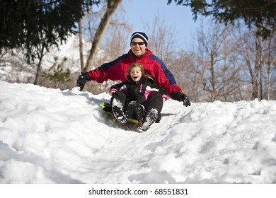 Family Having Fun Together Snow Sledding