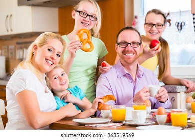 Family Having Joint Breakfast In Kitchen Eating And Drinking