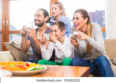 Family Having Leisure Time Together And Playing With Video Game Console