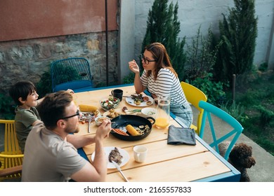 family having lunch in home backyard - Shutterstock ID 2165557833