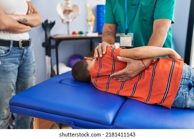 Family Having Physiotherapy Session Massaging Child Back At Rehab Clinic