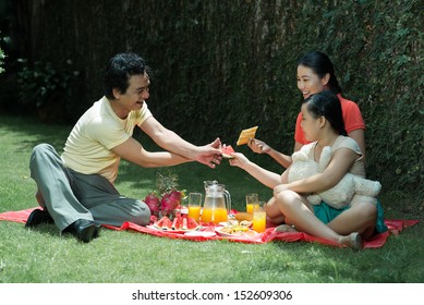 A Family Having Picnic On The Backyard Of Their Mansion 