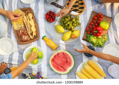 Family Having Picnic On Blanket In Park, Top View