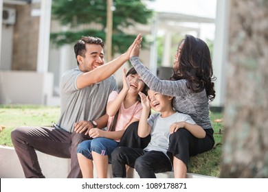 Family Having Quality Time Together Outdoor. Beautiful Asian Family With Two Kids. High Five