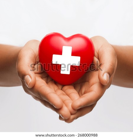 family health, charity and medicine concept - african american female hands holding red heart with cross sign