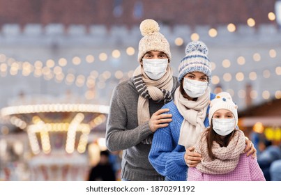 Family, Health And Winter Holidays Concept - Mother, Father And Little Daughter Wearing Face Protective Medical Mask For Protection From Virus Disease Over Christmas Market Background