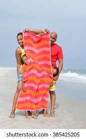 Family Hiding Behind Towel