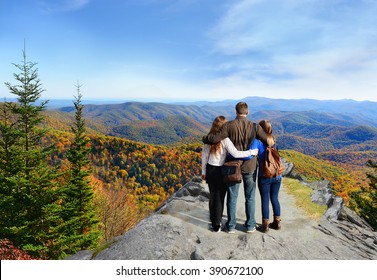 Family Hiking In Autumn Mountains Enjoying Beautiful Mountain View. People On Hiking Trip In Blue Ridge Mountains. North Carolina, USA.