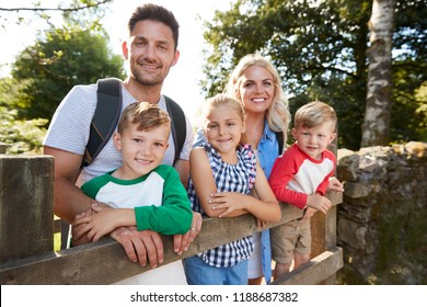 Family Hiking In Lake District UK Looking Over Wooden Gate