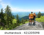 Family hiking on vacation, standing with arms around on top of the mountain, looking at beautiful summer mountains landscape. People enjoying beautiful view. North Carolina, USA.