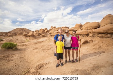 Family Hiking Together Among Desert Red Rock Formations At Goblin Valley State Park