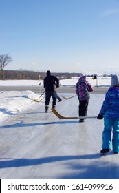 Family Hockey Game On Icy Driveway In Country