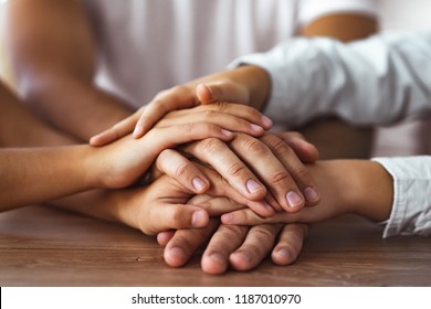 The family hold hands together at the table - Shutterstock ID 1187010970